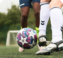 a soccer player is tackling another soccer player
